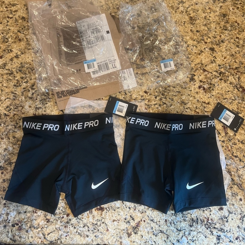 2 NWT black pairs of Nike Pro shorts girls size M.